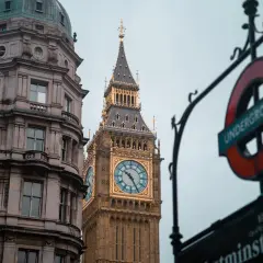 Edificio histórico y el Big Ben, un icono de los festivos UK, junto a un cartel del metro de Londres.