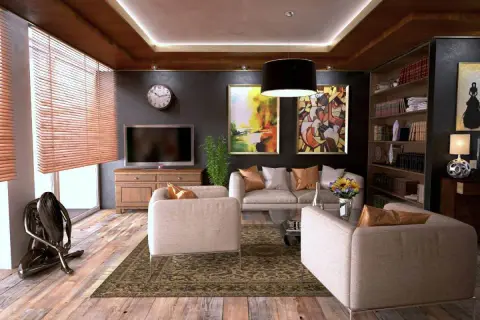 Elegantes habitaciones de una casa con sofás cómodos, arte abstracto y una estantería llena de libros.