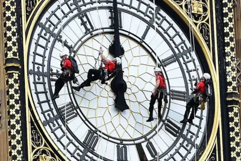 Trabajadores en rappel en el reloj Big Ben, ajustando las manecillas de este icónico reloj londinense.