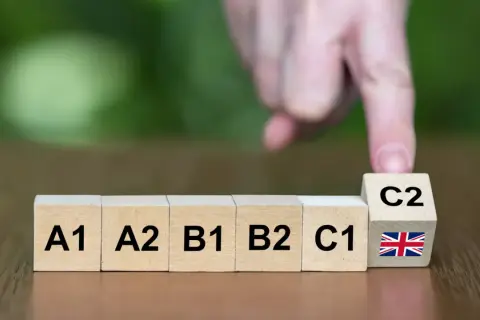 Bloques de madera muestran niveles de inglés: A1, A2, B1, B2, C1 y C2 con bandera británica. ¿Qué nivel de inglés te dan con el bachillerato?