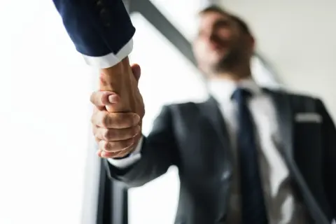 Dos hombres de negocios, Mr. y Mr., se dan la mano en un acuerdo.