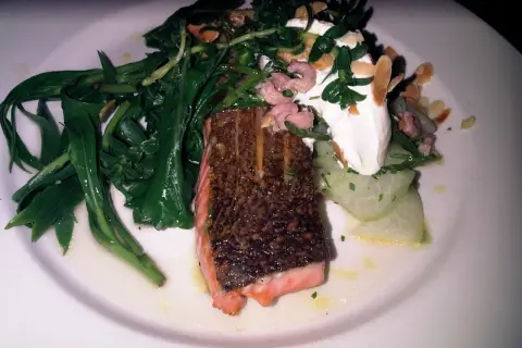 Salmón crujiente con espárragos verdes, gambas rosadas y una cucharada de crema. Un plato que evoca la comida inglesa.