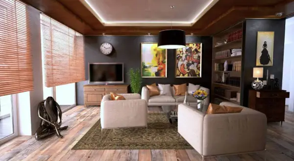 Elegantes habitaciones de una casa con sofás cómodos, arte abstracto y una estantería llena de libros.