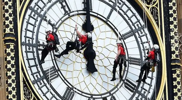 Trabajadores en rappel en el reloj Big Ben, ajustando las manecillas de este icónico reloj londinense.