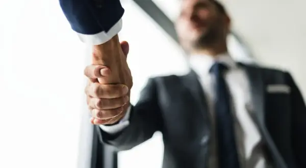 Dos hombres de negocios, Mr. y Mr., se dan la mano en un acuerdo.