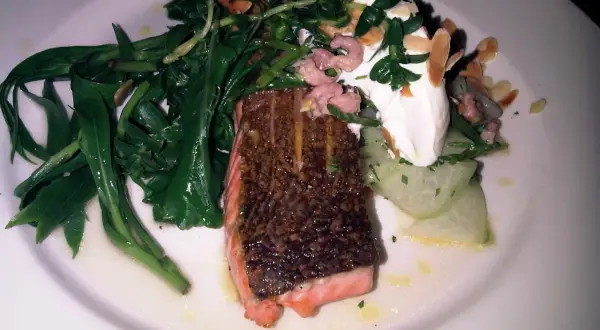 Salmón crujiente con espárragos verdes, gambas rosadas y una cucharada de crema. Un plato que evoca la comida inglesa.