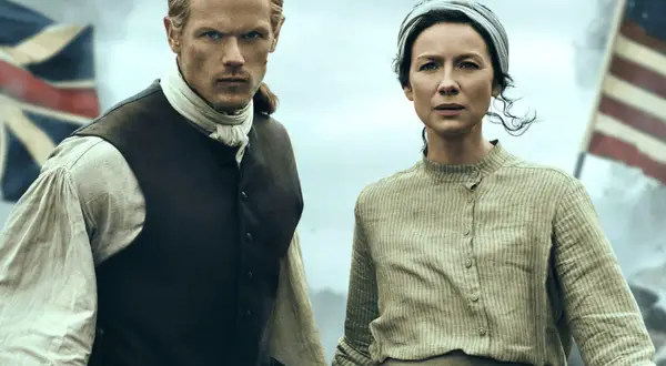 Jamie y Claire, protagonistas de series inglesas antiguas, se preparan para la batalla. Banderas ondean al fondo.