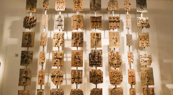 Colgando en el British Museum, obras famosas: placas de bronce con intrincadas escenas históricas y figuras humanas.
