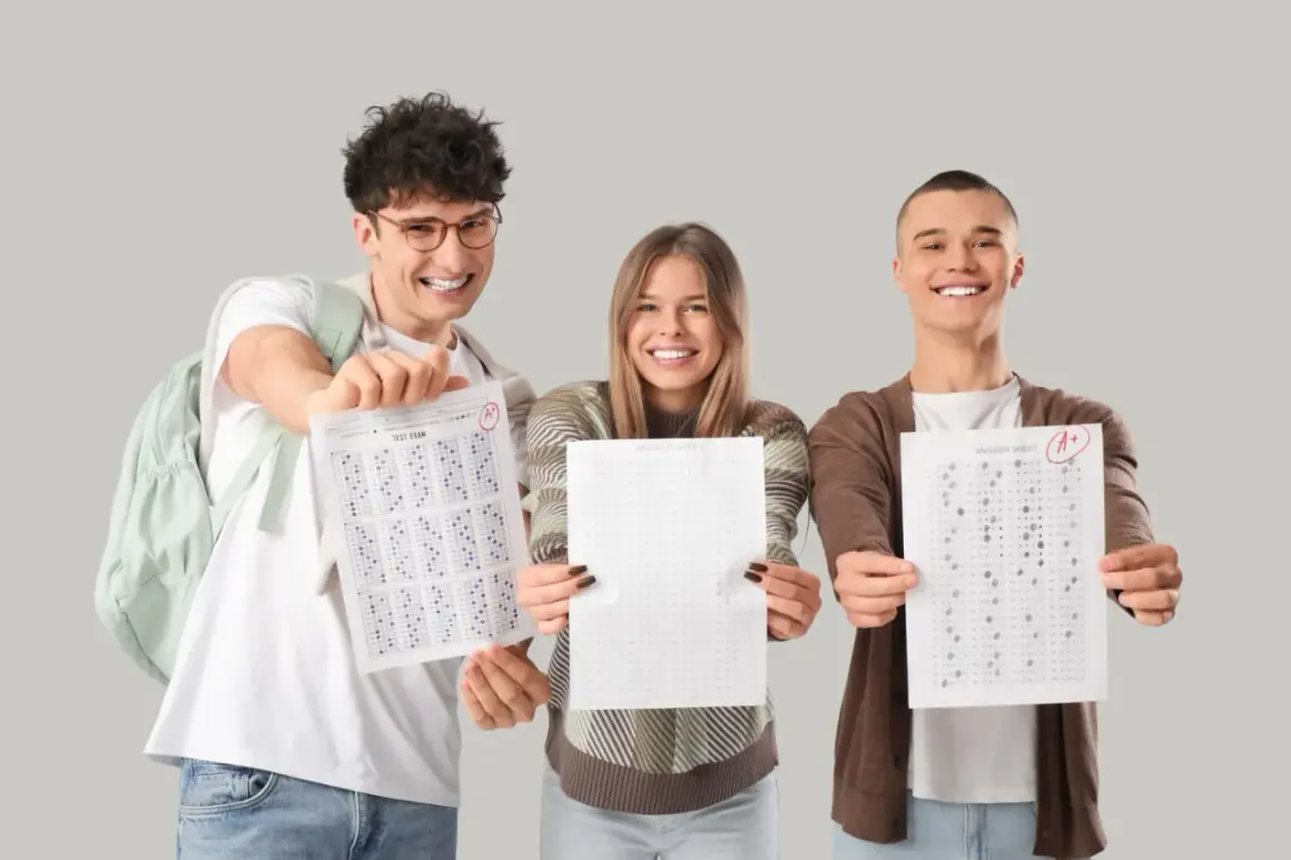 Tres estudiantes sonríen mostrando sus hojas de respuestas con puntuaciones aptis de A+.