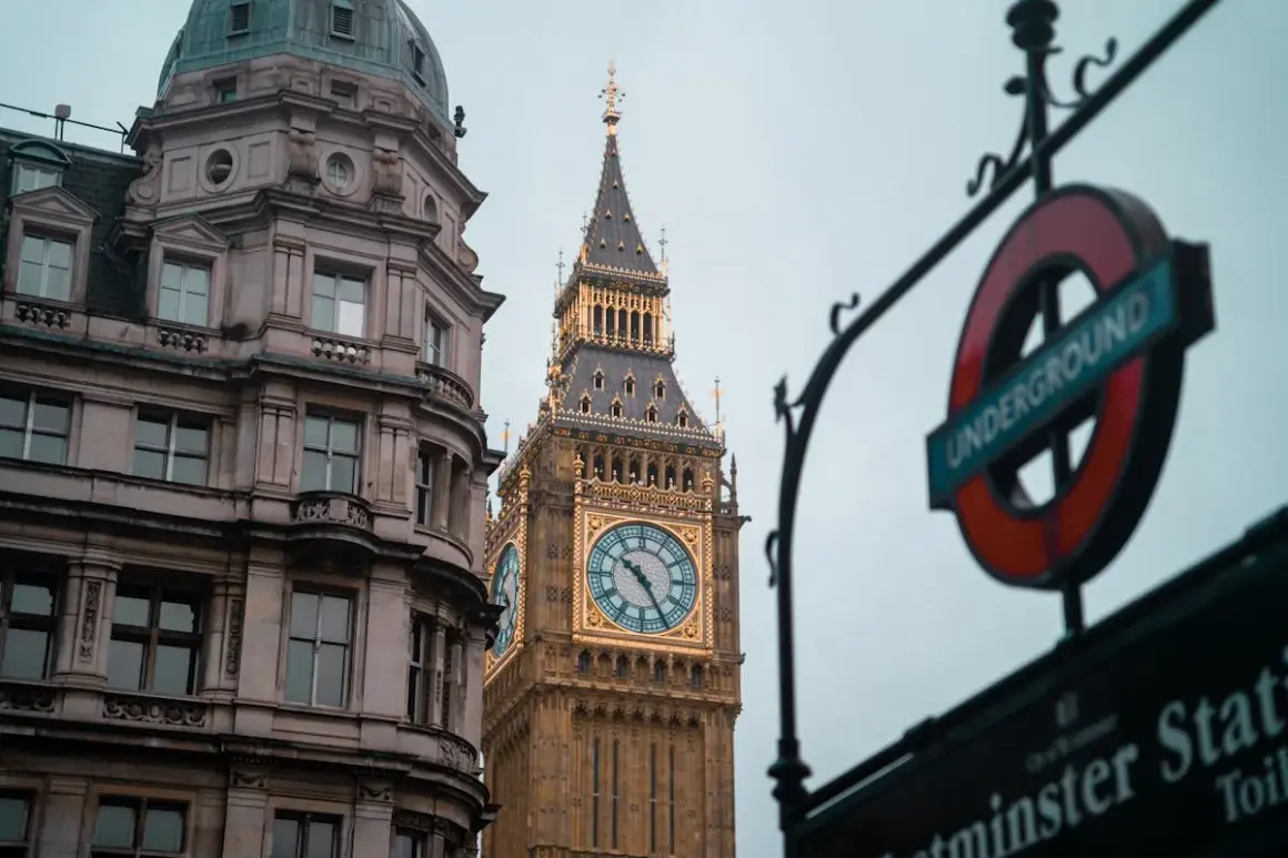 Edificio histórico y el Big Ben, un icono de los festivos UK, junto a un cartel del metro de Londres.