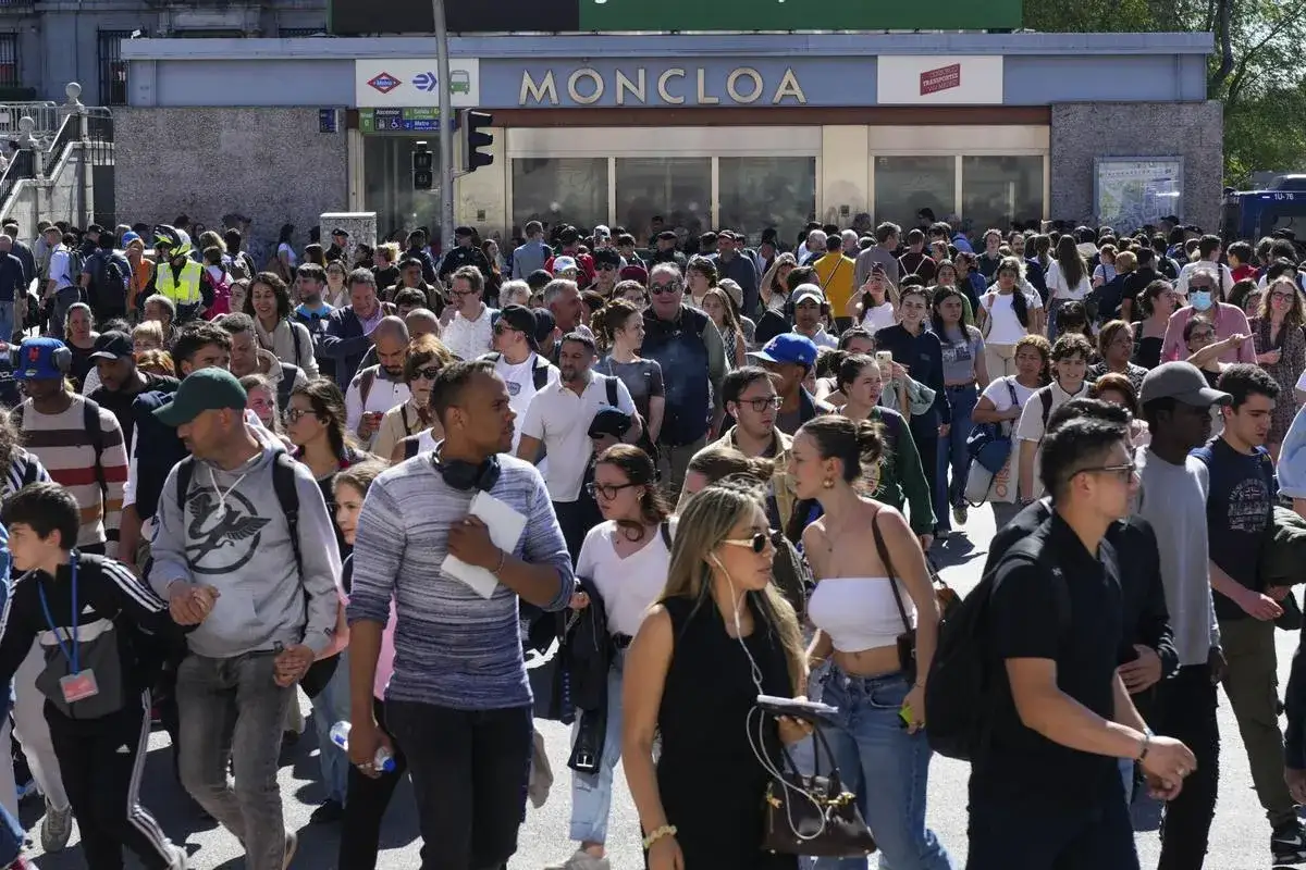 Una multitud de personas camina frente a la estaci&oacute;n de metro Moncloa.