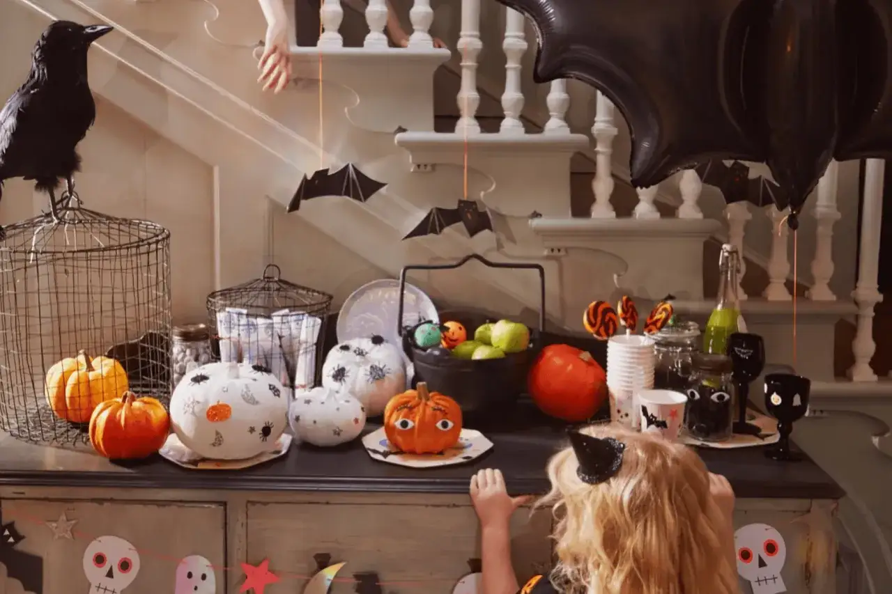Decoración de Halloween con calabazas, murciélagos colgantes y un cuervo. ¡Perfecto para encontrar frases de Halloween en inglés!