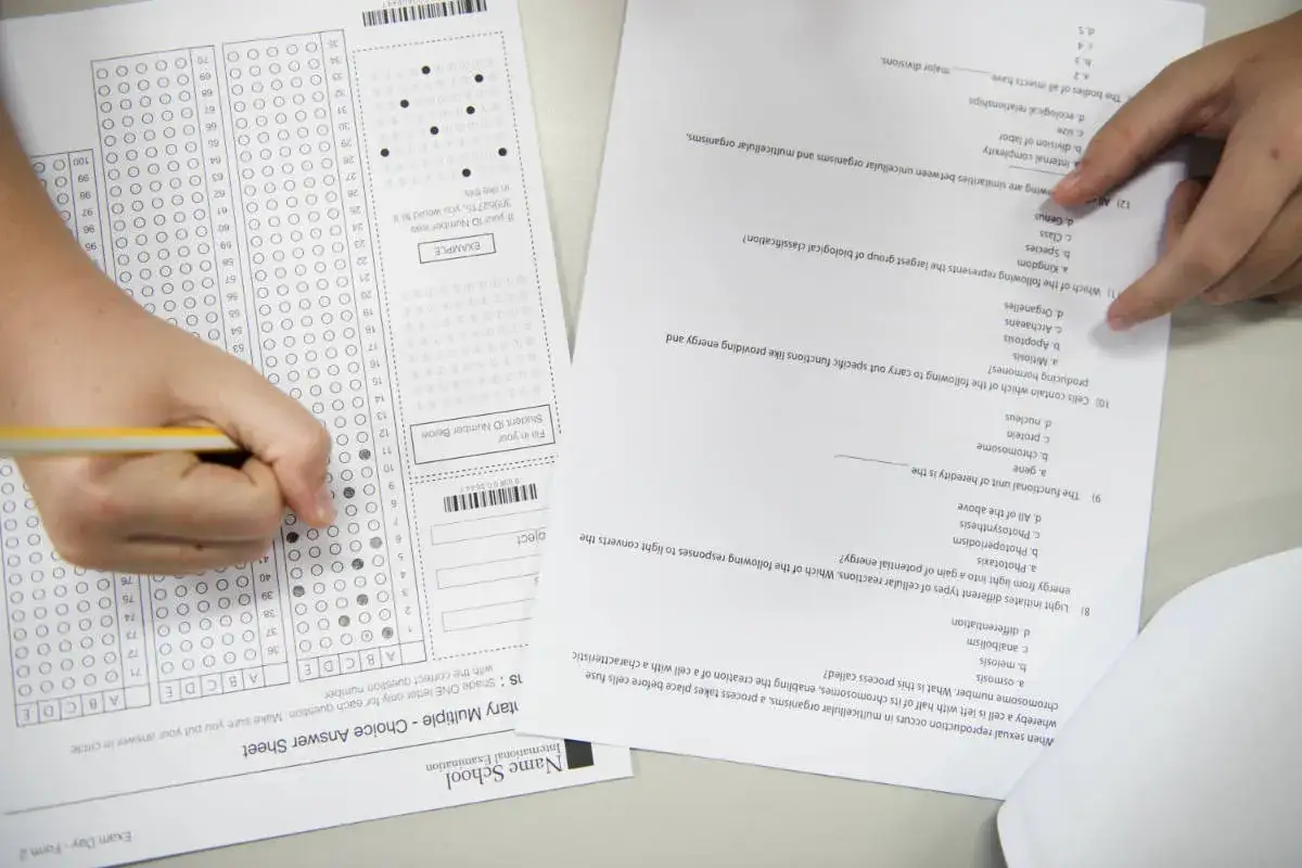 Estudiante completando un examen de opción múltiple, marcando respuestas en una hoja de respuestas.