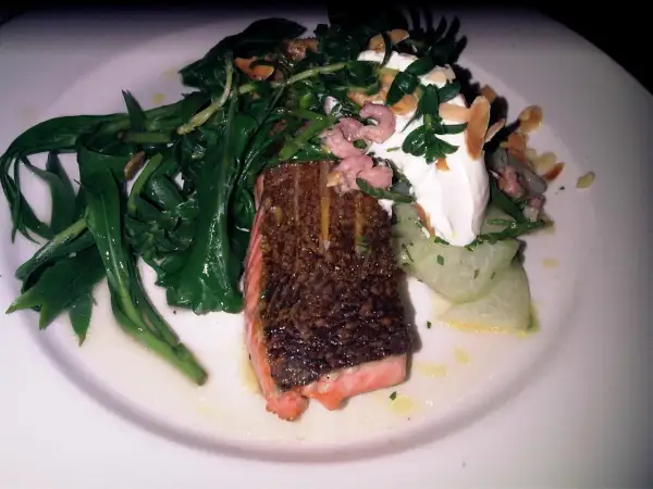 Salmón crujiente con espárragos verdes, gambas rosadas y una cucharada de crema. Un plato que evoca la comida inglesa.