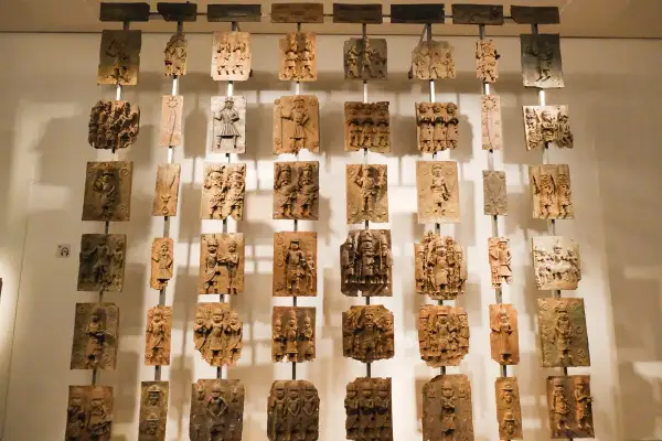 Colgando en el British Museum, obras famosas: placas de bronce con intrincadas escenas históricas y figuras humanas.